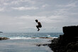 © Adrian Rodd/Stocksy - Long shot of a person diving into a natural basin among sharp rocks