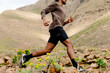 © Adrian Rodd/Stocksy - Unidentified man sprints along a gravel path in a mountainous region