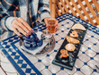 © EdNurg - Woman pouring hot tea from a blue teapot, enjoying traditional Moroccan pastries in a riad courtyard