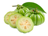 Close up of fresh green garcinia cambogia fruit with slices and leaf on a white surface showing seeds