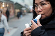 © Johnér - Close-up of woman wearing eyeglasses using asthma inhaler