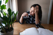 © Johnér - Sad woman drinking alcohol while sitting at table in home