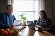 © Johnér - Mature man reading financial bill while woman using laptop at home