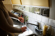 © Johnér - Midsection of pregnant woman washing glass with faucet water in kitchen sink