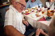 © Johnér - High angle view of smiling senior man enjoying leisure time with friends at lunch