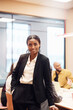 © Johnér - Portrait of confident female business professional standing with hand in pocket at office
