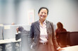 © Johnér - Portrait of smiling female corporate professional standing with hand in pocket at office