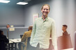 © Johnér - Portrait of happy male entrepreneur standing with hand in pocket at office