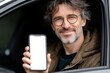 © Jane_S - Caucasian mature male with glasses shows blank phone screen in car