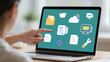 © Stock - Person pointing at laptop screen displaying file folder cloud and document icons on a green background