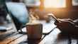 © PengAI - A steaming coffee mug sits on a wooden table next to a laptop, while a person uses a smartphone in warm morning light.