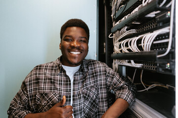 Poster - Young technician smiling confidently while working in server room