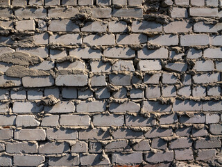 Poster - A brick wall with a lot of cracks and holes