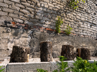 Poster - Four wooden logs are sitting on a brick wall