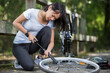 © auremar - young woman pumping up a bike tire