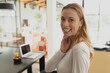 © WavebreakMediaMicro - Woman standing beside dining table under pendant lamp in open-plan home with laptop, juice, fruit