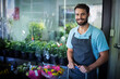 © wavebreak3 - Smiling male florist leaning on cart handle in flower shop with plants and bouquets, copy space