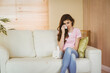 © WavebreakMediaMicro - Woman sitting on sofa in living room holding tissue wiping tears beside tissue box