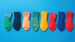 © tashechka - Colorful collection of socks arranged neatly on a blue background