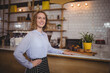 © WavebreakMediaMicro - Female barista wearing striped apron serving muffins on board behind countertop at cafe, copy space