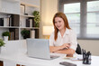 © jojo - Young woman working on a white desk with a laptop.