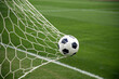 © GenAi - Photo of Soccer ball in the net on a green field, symbolizing a goal scored during a game, highlighting the excitement and competition of the sport