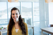 © WavebreakMediaMicro - Woman standing by computer monitor and table in bright open-plan office overlooking water and hills