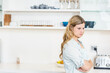 © WavebreakMediaMicro - Woman standing at home kitchen counter near stainless steel toaster and bowl of fruit, copy space
