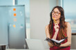 © WavebreakMediaMicro - Woman sitting at desk in modern office holding notebook and pencil before laptop, copy space