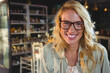 © WavebreakMediaMicro - Woman with blonde hair wearing jacket standing in shop under pendant lights among jars and bottles