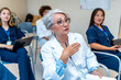 © unai - Senior doctor leading medical conference, explaining with hand gestures