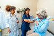 © unai - Nurse measuring blood pressure of senior woman with doctor supervising
