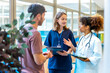 © unai - Doctors and nurse discussing patient's medical history in hospital corridor