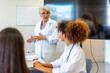 © unai - Senior doctor leading medical training for young professionals in hospital conference room