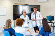 © unai - Medical team meeting discussing patient charts in hospital conference room