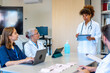 © unai - Medical team meeting discussing patient cases in hospital conference room