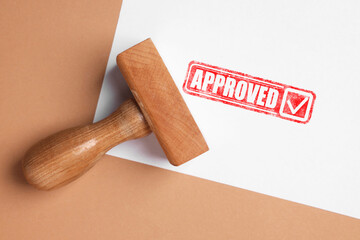 Fototapete - Sheet of paper with red stamp Approved and wooden stamp on pale brown background