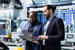 © DC Studio - Team of diverse analysts consultants reviewing data and checklists in a high tech solar panel plant, ensuring manufacturing process meets sustainable energy and innovation standards.