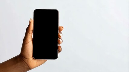 Poster - Close up of an ethnic female hand holding a blank screen mobile phone against a bright neutral background for app mockups