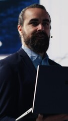 Poster - Vertical Video Visionary business leader gives detailed business pitch using data and graphs in a packed public speaking event. Audience listening as the CEO expert shares growth and success insight
