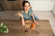 © Pixel-Shot - Happy young woman eating tasty sushi rolls at home