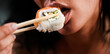 © Volodymyr - Sushi closeup in sexy woman mouth. Sexy woman eating sushi with chopsticks. Model eat sashimi. Sensual bite of sushi. Female tasting nigiri. Lunch at Japanese restaurant. Desire for delicious sushi.
