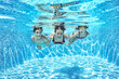 © Iuliia Sokolovska - Family swims underwater in swimming pool, happy active mother and children have fun under water, fitness and sport with kids on summer holiday vacation