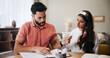 © peopleimages.com - Finance, documents and couple in home unsure for budget review, savings and payment mistake for mortgage. Marriage, confused and man with woman with paperwork, bills and financial expenses for taxes