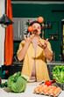 © Westend61 - Man juggling tomatoes in a kitchen with fresh vegetables and eggs on the counter