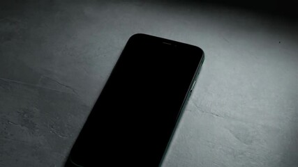 Poster - Modern smartphone with black screen on gray textured surface; Minimalist phone concept for technology, communication, and blank screens.