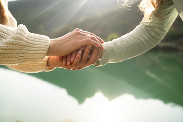 close-up of two women holding hands in nature, symbol of female friendship, trust, empathy and suppo