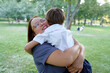 © Loginova - Mother and Child Embracing Joyfully in a Green Park During a Sunny Day..