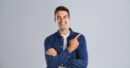 Poster - Pointing, offer and man in studio, portrait and announcement discount deal on gray background. Person, mockup space and model with hand gesture, opportunity and choice with sales, decision and smile