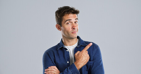 Poster - Pointing, portrait and man in studio, promotion and announcement on gray background. Person, mockup space and model with hand gesture, choice and discount deal with sales, decision and confidence